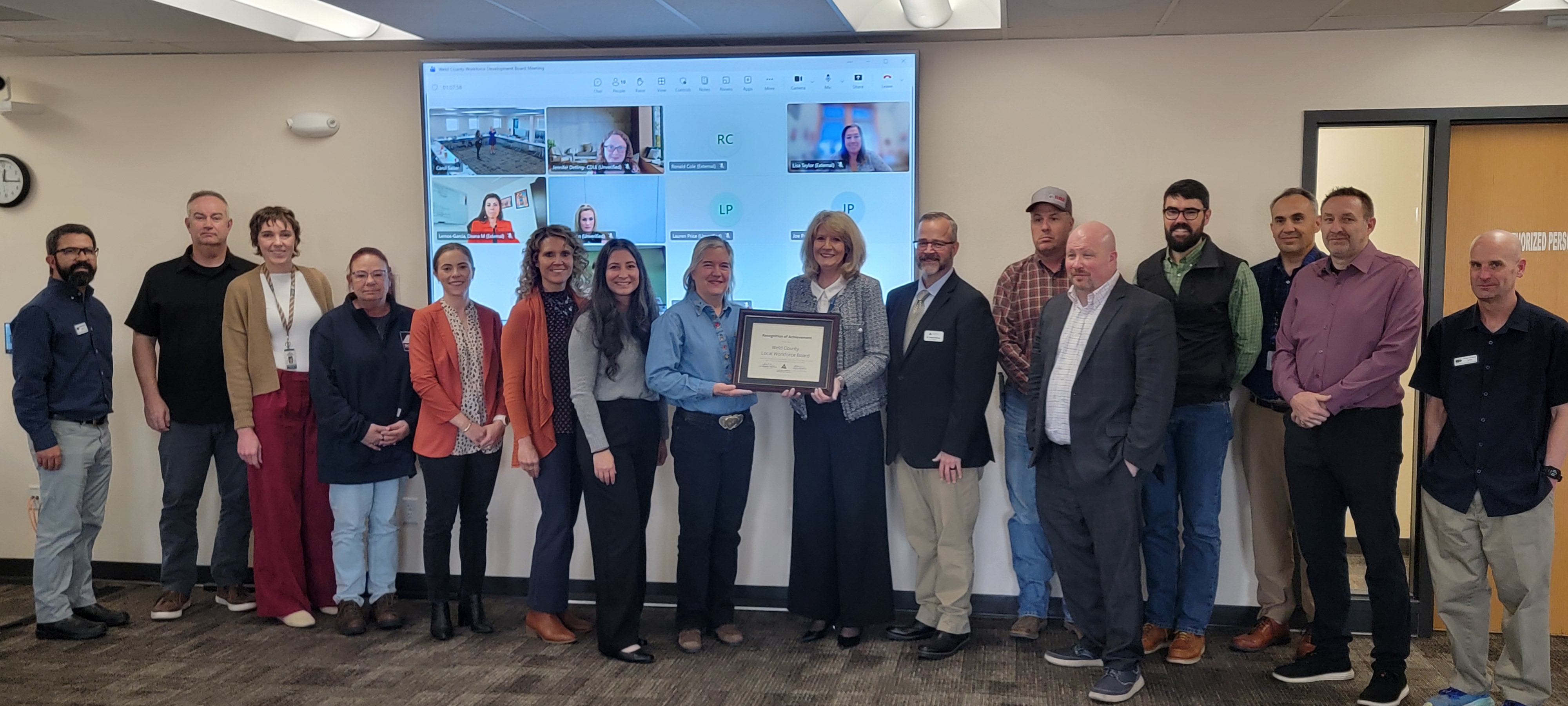 Photo of Weld County Workforce Board members accepting award in large conference room.