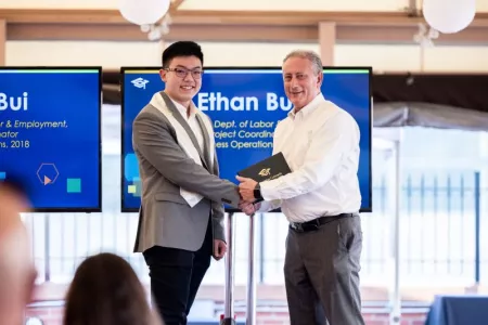 Ethan Bui receives his certificate of completion for his apprenticeship