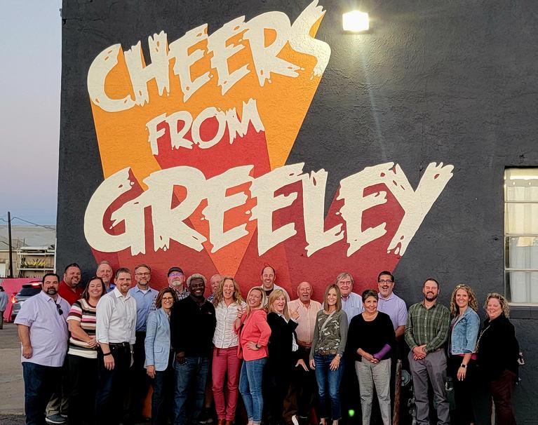 Colorado Workforce Development Council poses for group photo in front of community mural in Greeley, CO