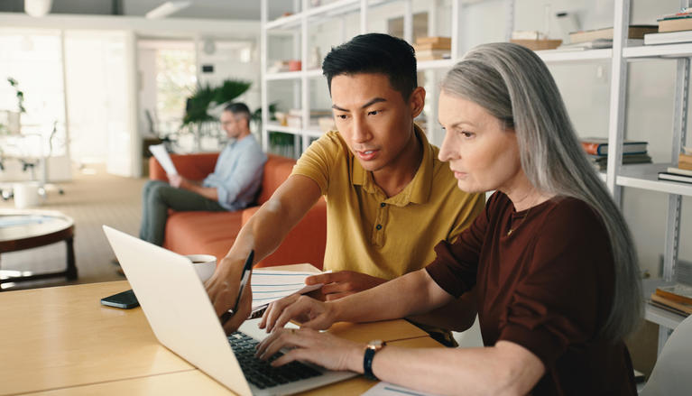 Asian worker and older woman on computer exploring My Colorado Journey online platform